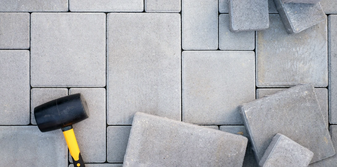Szara kostka brukowa i gumowy młotek